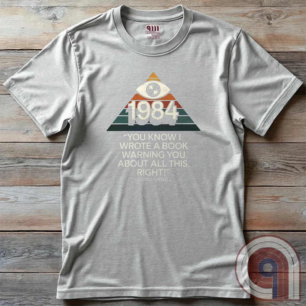 Big Brother Is All Seeing. This Orwellian dystopia shirt captures the chilling reality of mass surveillance, censorship, and authoritarian thought control. Designed for those who reject propaganda and resist digital tyranny, this bold graphic tee is a must-have for defenders of free speech. Every camera, every data log, every restriction—the system grows stronger. Stay vigilant, speak truth, and never submit to those who erase history to control the future. The fight for truth is far from over! Color: Ash