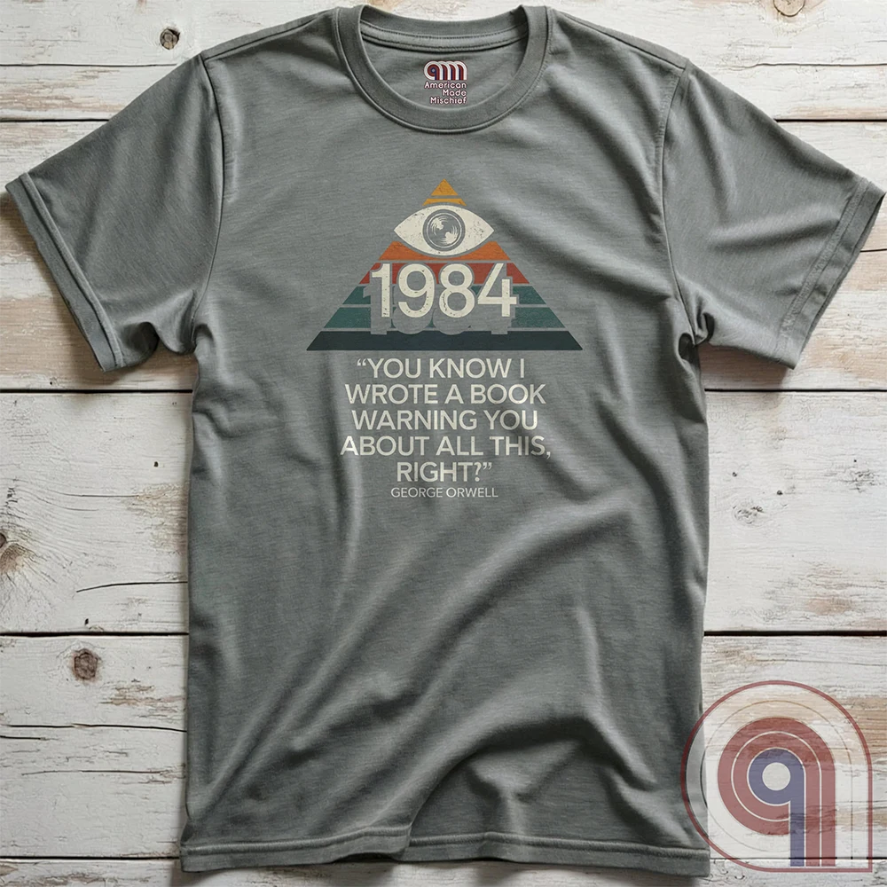 Big Brother Is All Seeing. This Orwellian dystopia shirt captures the chilling reality of mass surveillance, censorship, and authoritarian thought control. Designed for those who reject propaganda and resist digital tyranny, this bold graphic tee is a must-have for defenders of free speech. Every camera, every data log, every restriction—the system grows stronger. Stay vigilant, speak truth, and never submit to those who erase history to control the future. The fight for truth is far from over! Color: Grey