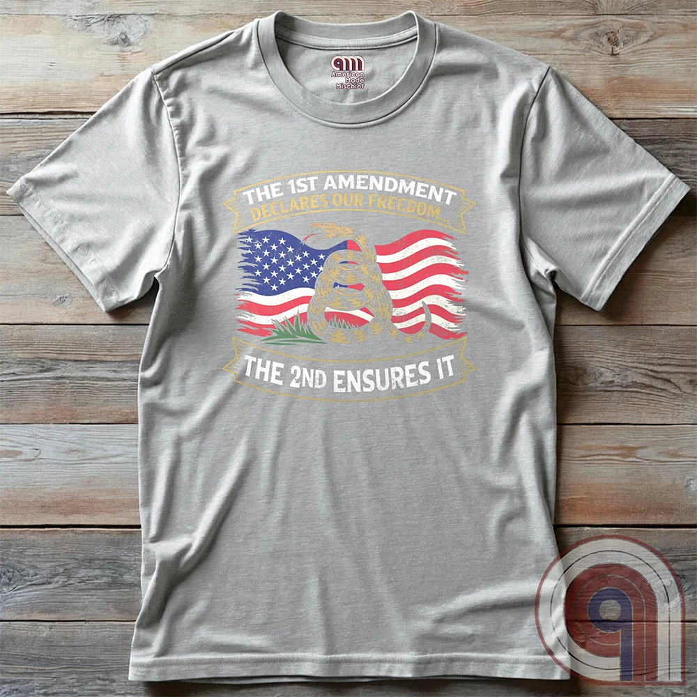 Stand for free speech and gun rights with this bold 1st & 2nd Amendment t-shirt. A distressed American flag with a coiled Gadsden snake, symbolizing freedom and resistance. ‘The 1st Amendment Declares Our Freedom… The 2nd Ensures It’ highlights the vital connection between free speech and the right to bear arms. A powerful design for gun rights advocates, patriots, and defenders of liberty who believe in self-defense, constitutional rights, and protecting American independence from tyranny. Color: Ash
