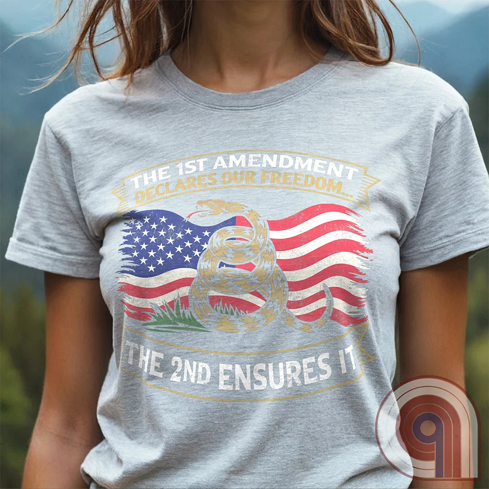 Stand for free speech and gun rights with this bold 1st & 2nd Amendment t-shirt. A distressed American flag with a coiled Gadsden snake, symbolizing freedom and resistance. ‘The 1st Amendment Declares Our Freedom… The 2nd Ensures It’ highlights the vital connection between free speech and the right to bear arms. A powerful design for gun rights advocates, patriots, and defenders of liberty who believe in self-defense, constitutional rights, and protecting American independence from tyranny. Color: Ash