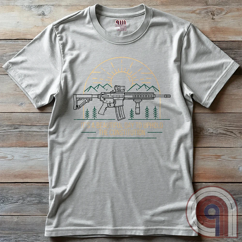 America was forged by the armed & unafraid. This ‘It’s a Beautiful Day to Uphold the Constitution’ t-shirt fuses the love of firearms with the untamed American spirit. Featuring an AR-15 set against rugged mountains and a blazing sunrise, this design screams independence, defiance, & unbreakable resolve. Whether you’re a hunter, soldier, or just a patriot who will not comply, this 2A shirt is a warning to tyrants: We don’t retreat. We reload. Wear it proudly and show that America will never bow; Color- Ash