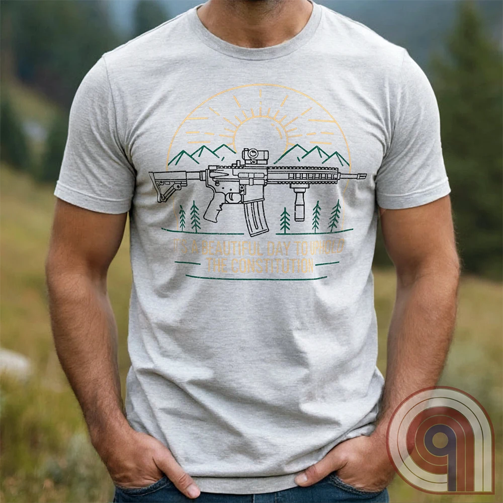America was forged by the armed & unafraid. This ‘It’s a Beautiful Day to Uphold the Constitution’ t-shirt fuses the love of firearms with the untamed American spirit. Featuring an AR-15 set against rugged mountains and a blazing sunrise, this design screams independence, defiance, & unbreakable resolve. Whether you’re a hunter, soldier, or just a patriot who will not comply, this 2A shirt is a warning to tyrants: We don’t retreat. We reload. Wear it proudly and show that America will never bow; Color- Ash