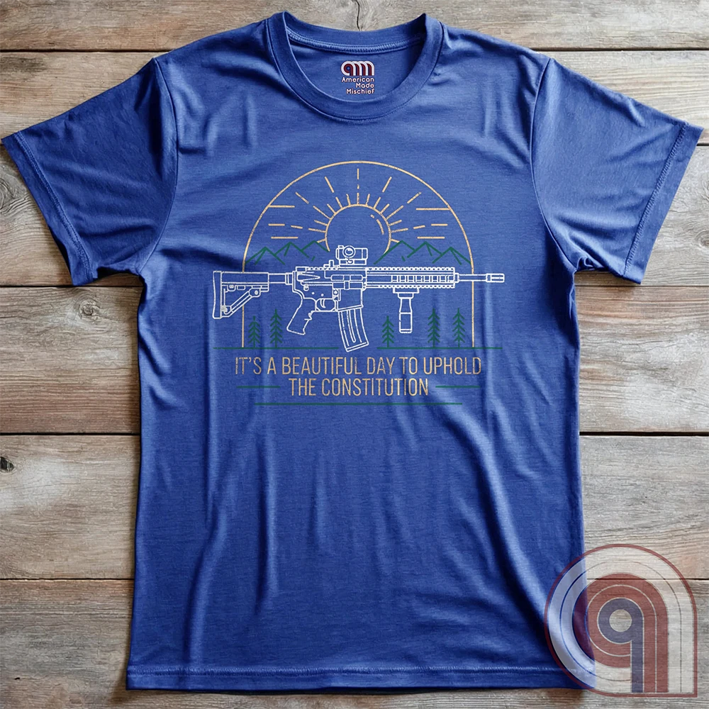 America was forged by the armed & unafraid. This ‘It’s a Beautiful Day to Uphold the Constitution’ t-shirt fuses the love of firearms with the untamed American spirit. Featuring an AR-15 set against rugged mountains and a blazing sunrise, this design screams independence, defiance, & unbreakable resolve. Whether you’re a hunter, soldier, or just a patriot who will not comply, this 2A shirt is a warning to tyrants: We don’t retreat. We reload. Wear it proudly and show that America will never bow; Color- Blue