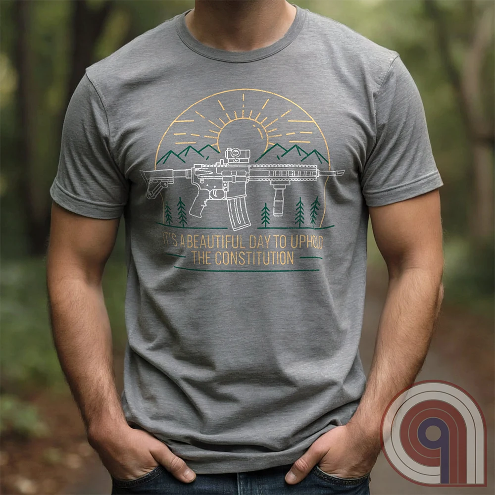 America was forged by the armed & unafraid. This ‘It’s a Beautiful Day to Uphold the Constitution’ t-shirt fuses the love of firearms with the untamed American spirit. Featuring an AR-15 set against rugged mountains and a blazing sunrise, this design screams independence, defiance, & unbreakable resolve. Whether you’re a hunter, soldier, or just a patriot who will not comply, this 2A shirt is a warning to tyrants: We don’t retreat. We reload. Wear it proudly and show that America will never bow; Color- Grey