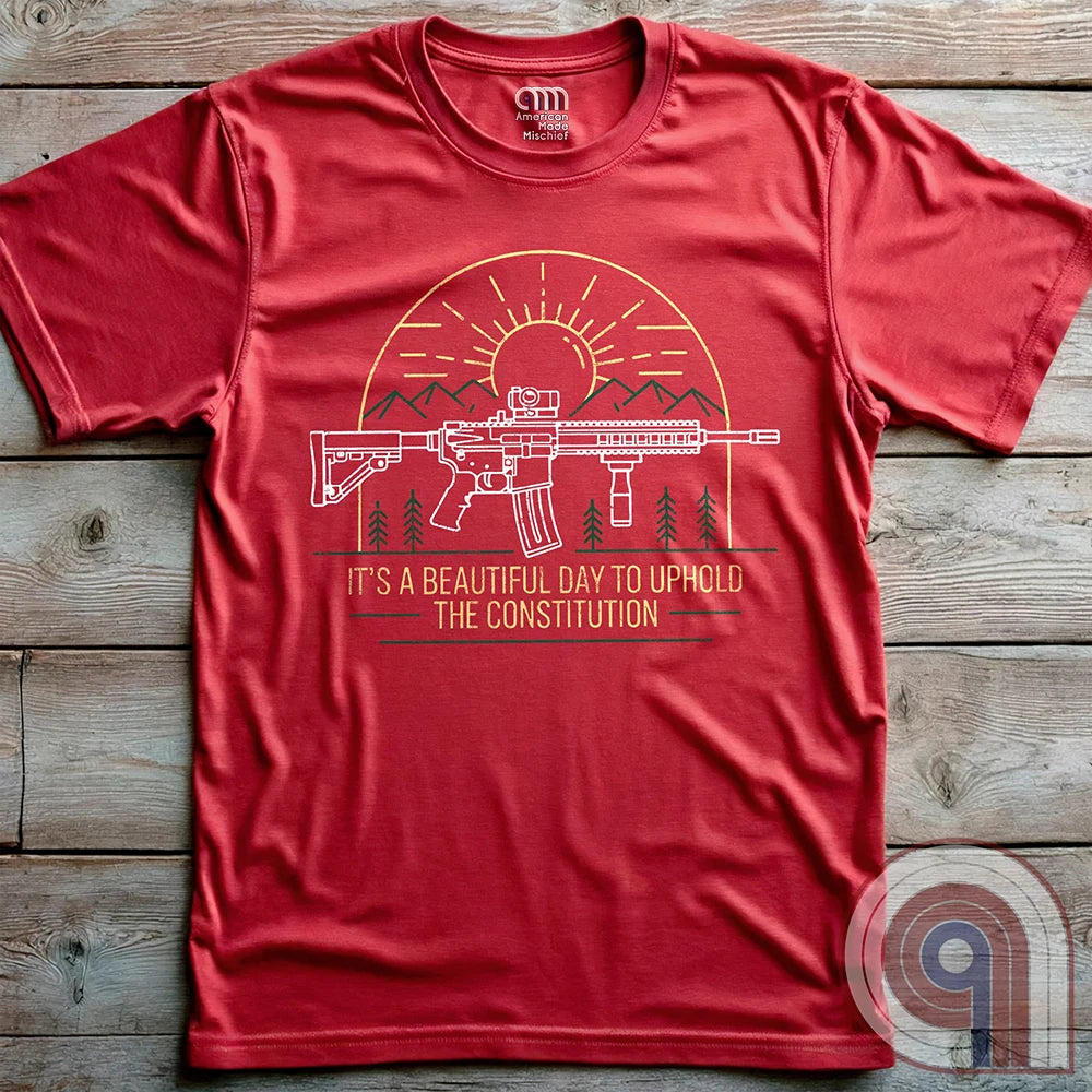 America was forged by the armed & unafraid. This ‘It’s a Beautiful Day to Uphold the Constitution’ t-shirt fuses the love of firearms with the untamed American spirit. Featuring an AR-15 set against rugged mountains and a blazing sunrise, this design screams independence, defiance, & unbreakable resolve. Whether you’re a hunter, soldier, or just a patriot who will not comply, this 2A shirt is a warning to tyrants: We don’t retreat. We reload. Wear it proudly and show that America will never bow; Color- Red