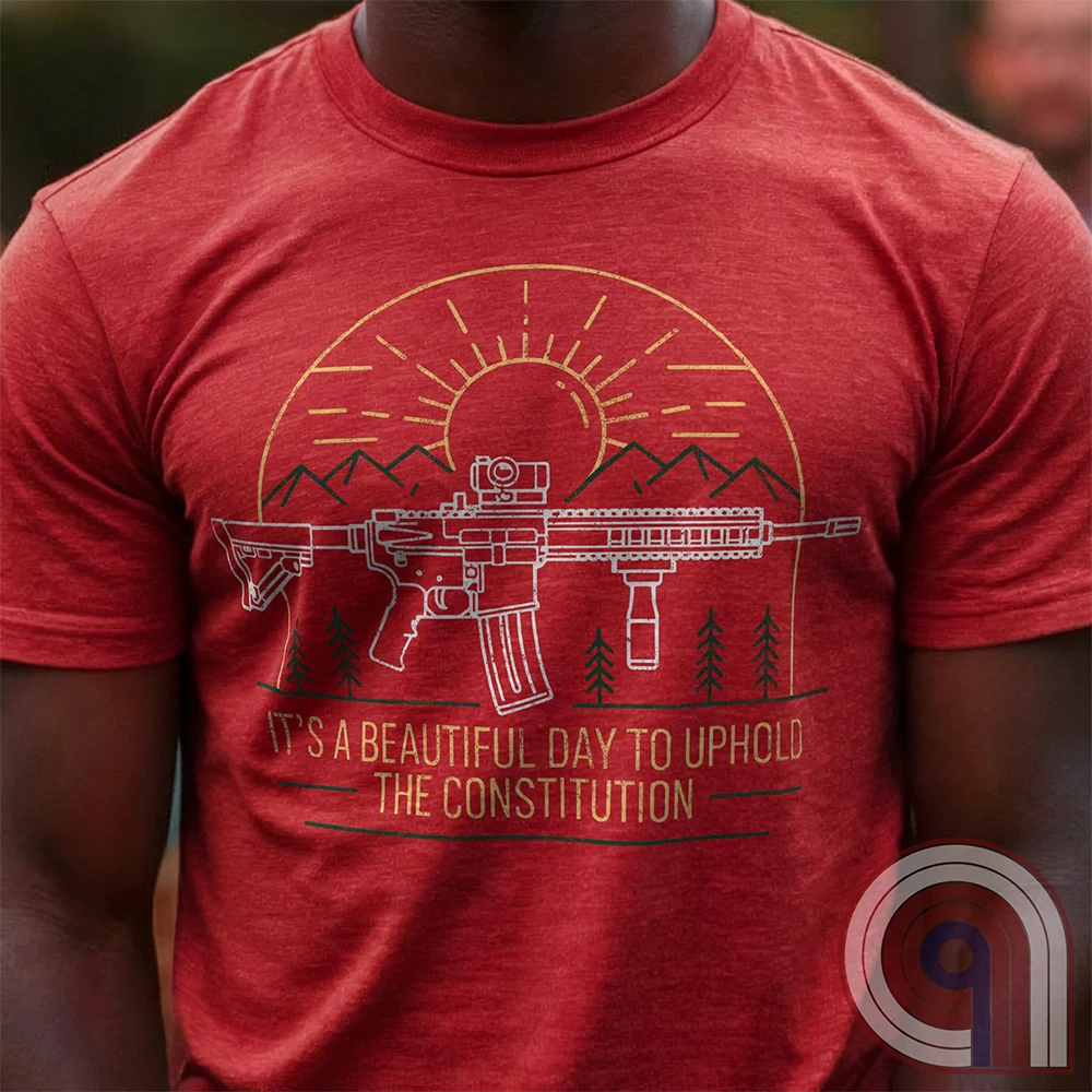 America was forged by the armed & unafraid. This ‘It’s a Beautiful Day to Uphold the Constitution’ t-shirt fuses the love of firearms with the untamed American spirit. Featuring an AR-15 set against rugged mountains and a blazing sunrise, this design screams independence, defiance, & unbreakable resolve. Whether you’re a hunter, soldier, or just a patriot who will not comply, this 2A shirt is a warning to tyrants: We don’t retreat. We reload. Wear it proudly and show that America will never bow; Color- Red