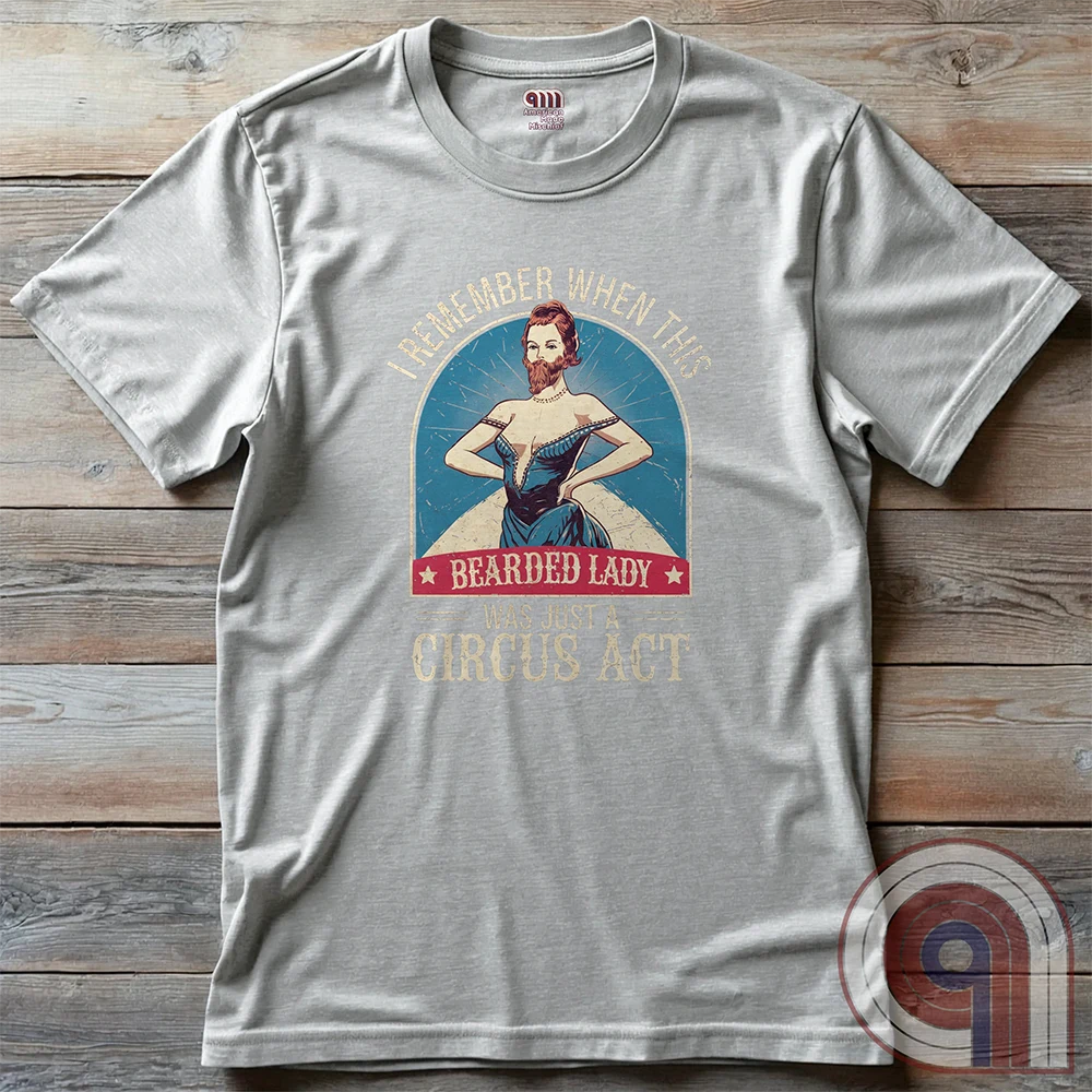 Step right up and witness the absurdity of modern times with this Bearded Lady Circus Act Freak Show Tee! Featuring a vintage sideshow design, this satirical shirt recalls an era when freak shows were confined to the circus tent—not celebrated in mainstream culture. Once a novelty act, now an everyday spectacle, this retro-inspired tee pokes fun at the bizarre shift in societal norms. Perfect for conservatives, free-thinkers, and those who refuse to accept forced narratives. Wear it loud! Color- Ash2