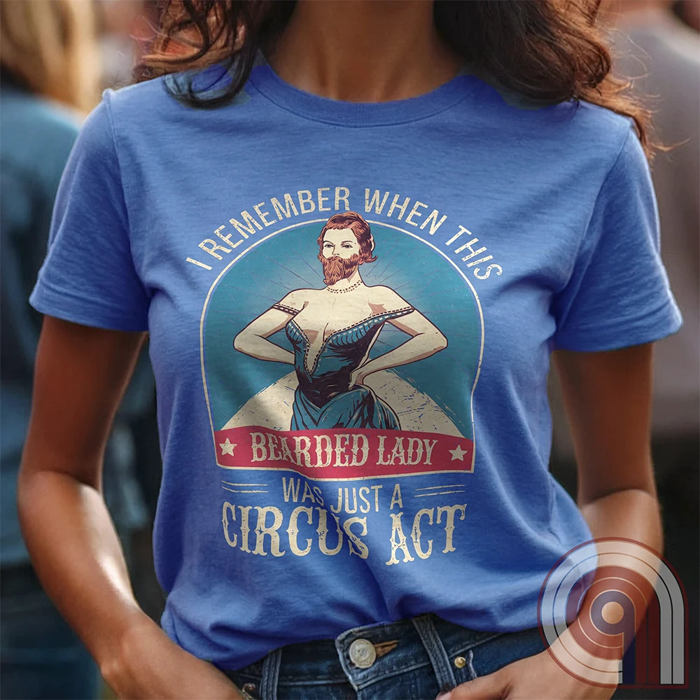 Step right up and witness the absurdity of modern times with this Bearded Lady Circus Act Freak Show Tee! Featuring a vintage sideshow design, this satirical shirt recalls an era when freak shows were confined to the circus tent—not celebrated in mainstream culture. Once a novelty act, now an everyday spectacle, this retro-inspired tee pokes fun at the bizarre shift in societal norms. Perfect for conservatives, free-thinkers, and those who refuse to accept forced narratives. Wear it loud! Color- Blue1