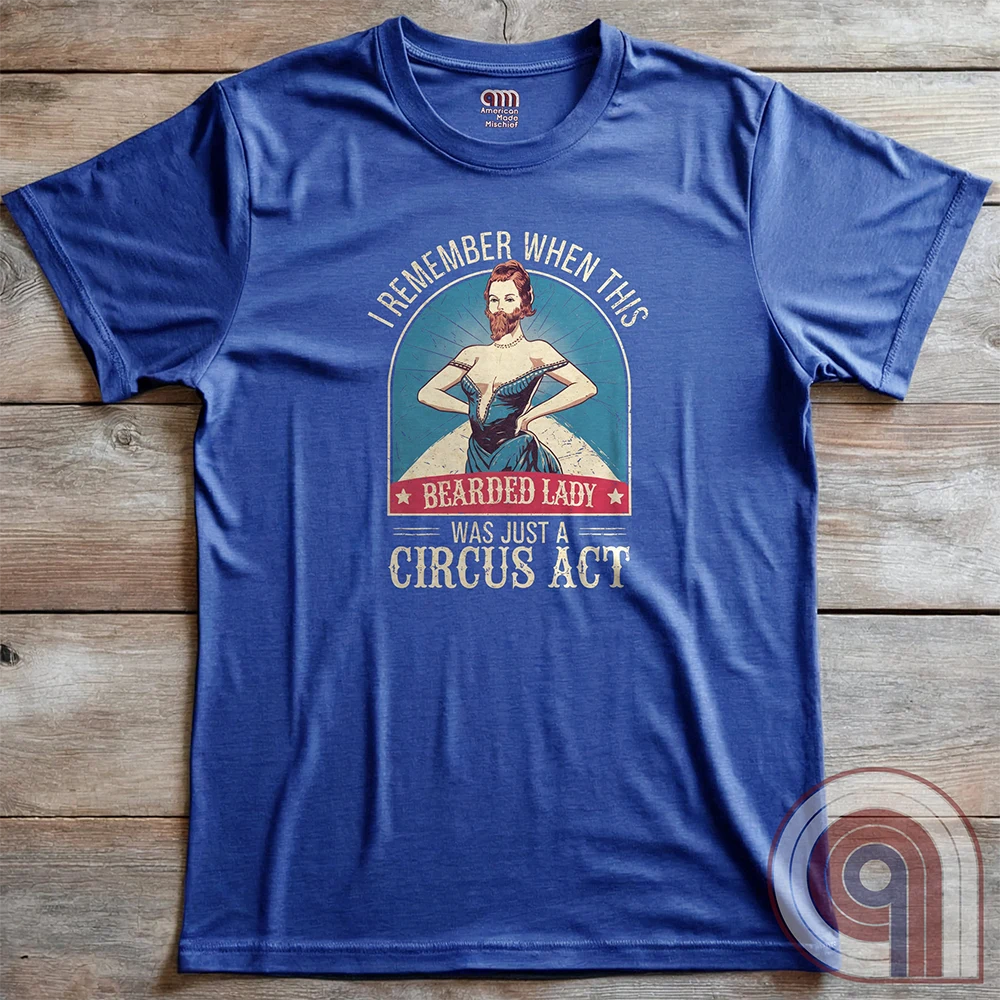 Step right up and witness the absurdity of modern times with this Bearded Lady Circus Act Freak Show Tee! Featuring a vintage sideshow design, this satirical shirt recalls an era when freak shows were confined to the circus tent—not celebrated in mainstream culture. Once a novelty act, now an everyday spectacle, this retro-inspired tee pokes fun at the bizarre shift in societal norms. Perfect for conservatives, free-thinkers, and those who refuse to accept forced narratives. Wear it loud! Color- Blue2