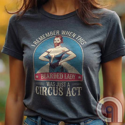 Step right up and witness the absurdity of modern times with this Bearded Lady Circus Act Freak Show Tee! Featuring a vintage sideshow design, this satirical shirt recalls an era when freak shows were confined to the circus tent—not celebrated in mainstream culture. Once a novelty act, now an everyday spectacle, this retro-inspired tee pokes fun at the bizarre shift in societal norms. Perfect for conservatives, free-thinkers, and those who refuse to accept forced narratives. Wear it loud! Color- Charc1