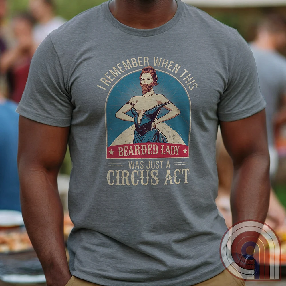 Step right up and witness the absurdity of modern times with this Bearded Lady Circus Act Freak Show Tee! Featuring a vintage sideshow design, this satirical shirt recalls an era when freak shows were confined to the circus tent—not celebrated in mainstream culture. Once a novelty act, now an everyday spectacle, this retro-inspired tee pokes fun at the bizarre shift in societal norms. Perfect for conservatives, free-thinkers, and those who refuse to accept forced narratives. Wear it loud! Color- Grey1