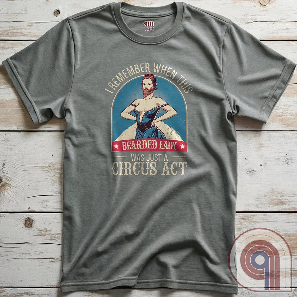 Step right up and witness the absurdity of modern times with this Bearded Lady Circus Act Freak Show Tee! Featuring a vintage sideshow design, this satirical shirt recalls an era when freak shows were confined to the circus tent—not celebrated in mainstream culture. Once a novelty act, now an everyday spectacle, this retro-inspired tee pokes fun at the bizarre shift in societal norms. Perfect for conservatives, free-thinkers, and those who refuse to accept forced narratives. Wear it loud! Color- Grey2