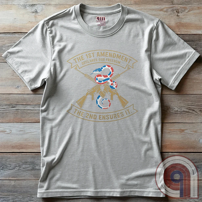 Show your commitment to the 1st & 2nd Amendments with this bold patriotic t-shirt. A fun 1A & 2A Tee featuring a red, white, & blue rattlesnake coiled around crossed rifles, this design represents free speech, gun rights, & resistance to tyranny. Perfect for Second Amendment supporters, constitutional patriots, & defenders of liberty. Whether you're standing against censorship or advocating for self-defense, this statement honors America’s founding principles and those who fight to protect them. Color: Ash