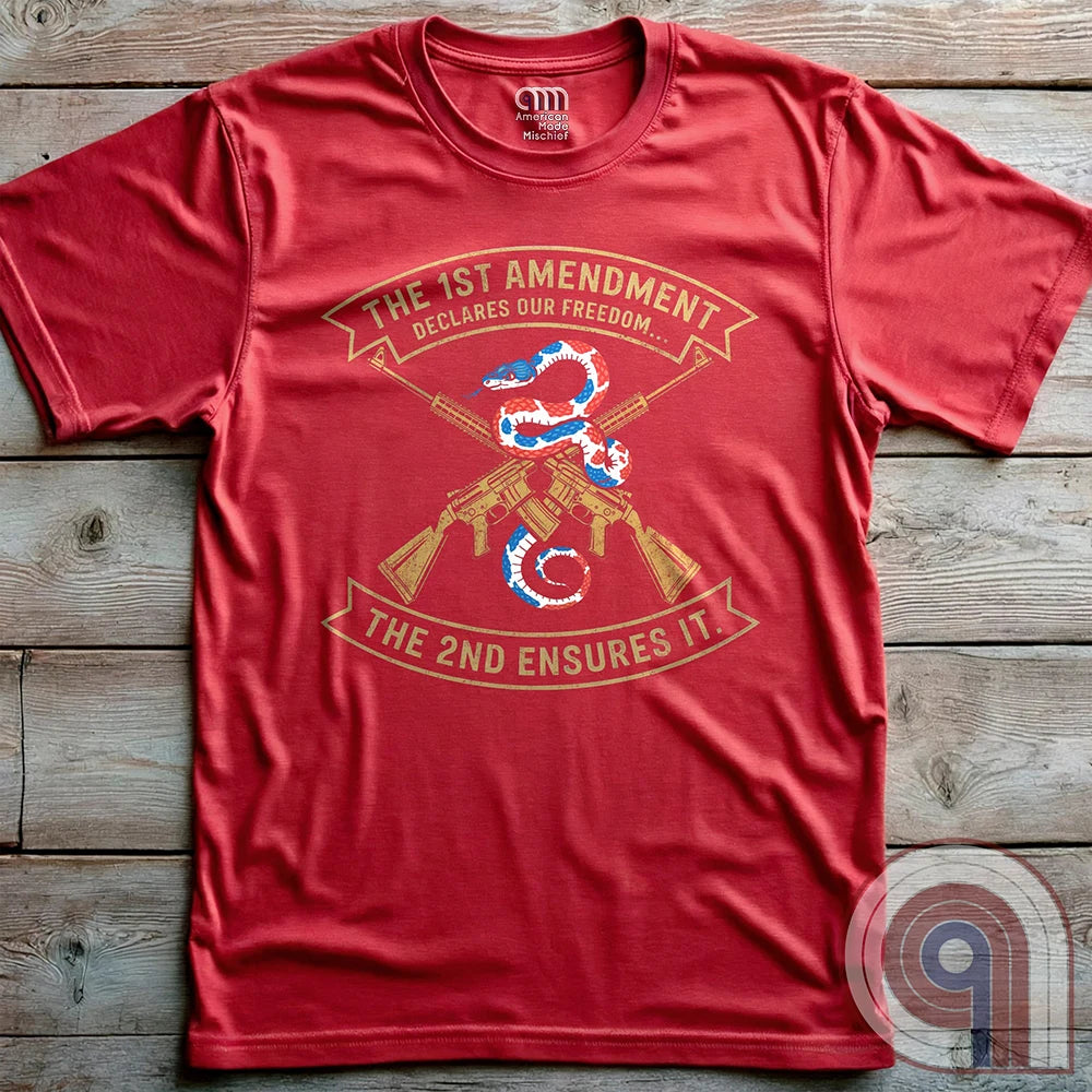 Show your commitment to the 1st & 2nd Amendments with this bold patriotic t-shirt. A fun 1A & 2A Tee featuring a red, white, & blue rattlesnake coiled around crossed rifles, this design represents free speech, gun rights, & resistance to tyranny. Perfect for Second Amendment supporters, constitutional patriots, & defenders of liberty. Whether you're standing against censorship or advocating for self-defense, this statement honors America’s founding principles and those who fight to protect them. Color: Red
