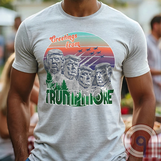 Celebrate American greatness with the "Greetings from Mt. Trumpmore" T-shirt, a bold patriotic parody of Mount Rushmore featuring Donald Trump’s face carved in stone. A retro-style souvenir tee perfect for MAGA supporters, conservatives, & those who see Trump as one of America’s greatest presidents. With vintage postcard aesthetics, fighter jets soaring in the sunset, & a nod to national pride, this Trump tribute shirt is a must-have for patriots who refuse to apologize for loving the USA. Color - Ash1