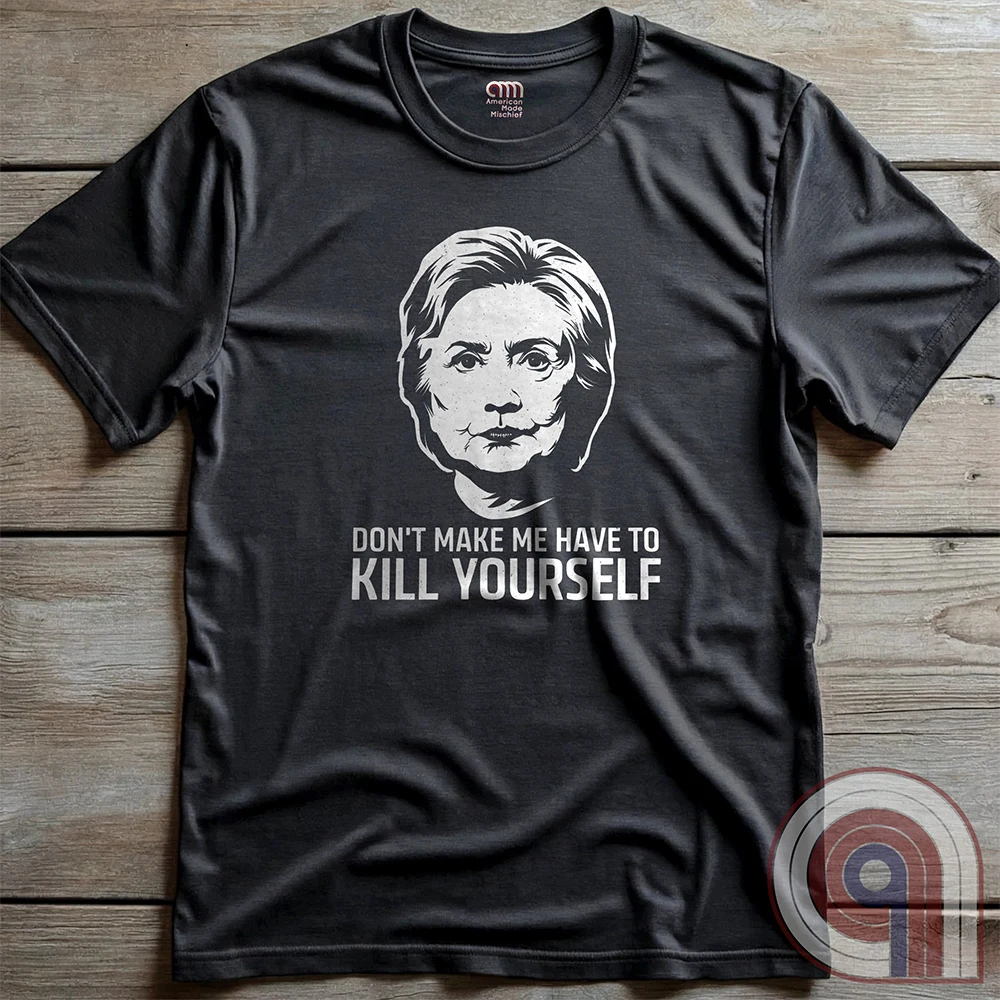 Charcoal shirt laid flat on a wood surface, showing a light-colored Clinton portrait with the full “DON'T MAKE ME HAVE TO KILL YOURSELF” slogan in two contrasting text sizes.