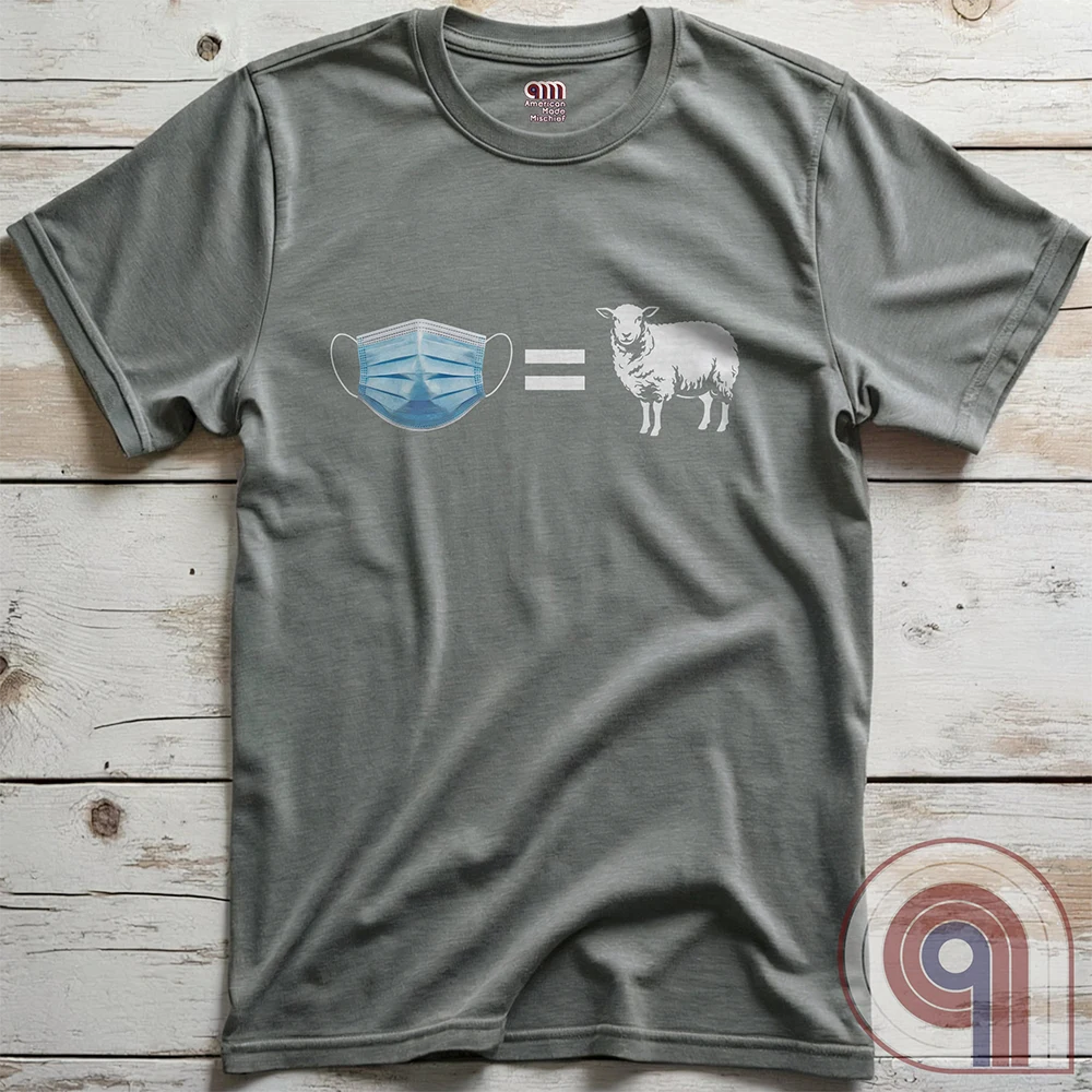 Heather grey tee photographed flat on wooden boards, with no words—just a light-blue face mask, an equals sign and a white sheep across the chest.