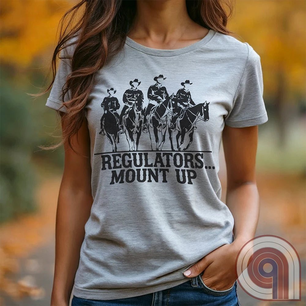 Ride high with the 'Regulators... Mount Up' t-shirt, a fearless call to action for patriots who stand for unity, resilience, & the preservation of American values. Inspired by frontier justice, this Western tee embodies the spirit of Texas Rangers, Border Patrol Agents, & Minute-Men. A tribute to law & order, standing strong, & defending freedom, it's perfect for those who believe in 2A, 1A, & American spirit. Whether you're a cowboy, prepper, or patriot, wear it with pride and ride for liberty. Ash