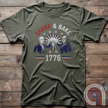 Revolution meets the racetrack with this Talladega Nights-inspired “Shake & Bake 1776” design, featuring George Washington and Benjamin Franklin throwing a victorious fist bump. A patriotic mashup of NASCAR culture and Founding Father grit, this tee celebrates American independence with speed, style, and historical swagger. Perfect for history buffs, liberty lovers, and anyone who believes in freedom, fast cars, and finishing first—because if you ain’t first, you’re last! Comedy Parody Tee. Color- Green