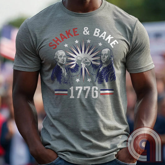 Revolution meets the racetrack with this Talladega Nights-inspired “Shake & Bake 1776” design, featuring George Washington and Benjamin Franklin throwing a victorious fist bump. A patriotic mashup of NASCAR culture and Founding Father grit, this tee celebrates American independence with speed, style, and historical swagger. Perfect for history buffs, liberty lovers, and anyone who believes in freedom, fast cars, and finishing first—because if you ain’t first, you’re last! Comedy Parody Tee. Color-Grey