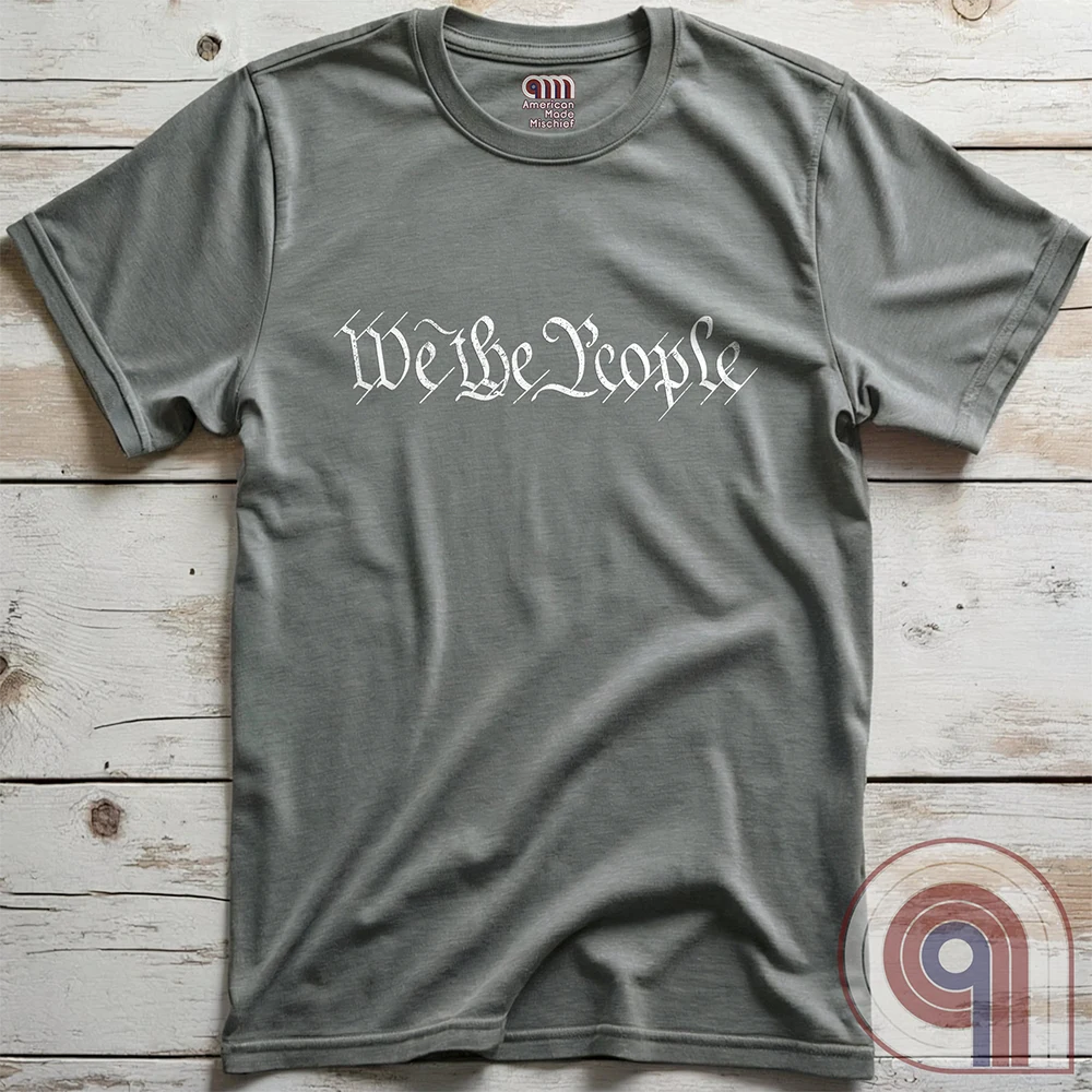 Show your patriotism with this bold 'We The People' t-shirt, inspired by the U.S. Constitution. Featuring classic calligraphy from the founding document, this design represents American freedom, liberty, & the power of the people. Perfect for proud patriots, constitutionalists, & those who stand for individual rights. Celebrate the Bill of Rights, defend the Second Amendment, & stand for limited government with this statement of American values, independence, self-governance, & personal liberty. Color- Grey