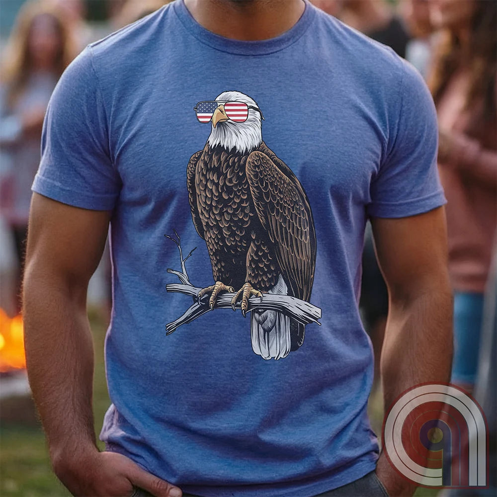 Declare your independence with this striking Pro USA t-shirt featuring America’s ultimate symbol of freedom—the bald eagle—sporting American flag sunglasses. It’s not just a patriotic tee—it’s a statement of strength, sovereignty, and pride. 
Bald eagle t-shirt;Patriotic eagle shirt;American flag sunglasses design;USA freedom shirt;Pro-America graphic tee;Unisex patriotic t-shirt;Eagle with American flag glasses shirt;Conservative values;July 4th eagle t-shirt;USA-made freedom apparel;MAGA;1776; - Blue
