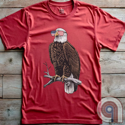 Declare your independence with this striking Pro USA t-shirt featuring America’s ultimate symbol of freedom—the bald eagle—sporting American flag sunglasses. It’s not just a patriotic tee—it’s a statement of strength, sovereignty, and pride. 
Bald eagle t-shirt;Patriotic eagle shirt;American flag sunglasses design;USA freedom shirt;Pro-America graphic tee;Unisex patriotic t-shirt;Eagle with American flag glasses shirt;Conservative values;July 4th eagle t-shirt;USA-made freedom apparel;MAGA;1776; - Red
