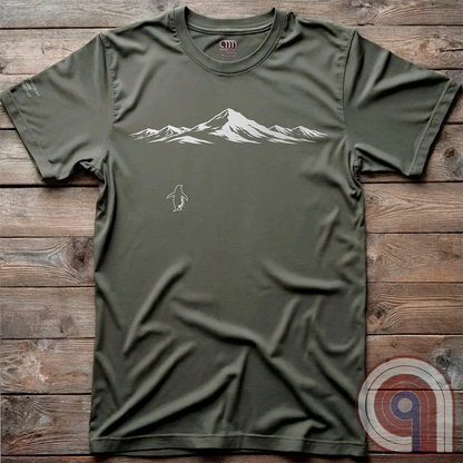 Minimalist inspirational t-shirt graphic showing a lone penguin walking away beneath a vast snow-covered mountain range, inspired by Werner Herzog’s wandering penguin documentary scene. This Tee evokes existential solitude, Faustian spirit, nihilism, faith, and quiet bravery, symbolizing the call to adventure, isolation, perseverance, philosophy, and the human search for meaning through nature, exploration, and understated surreal meme culture. Green