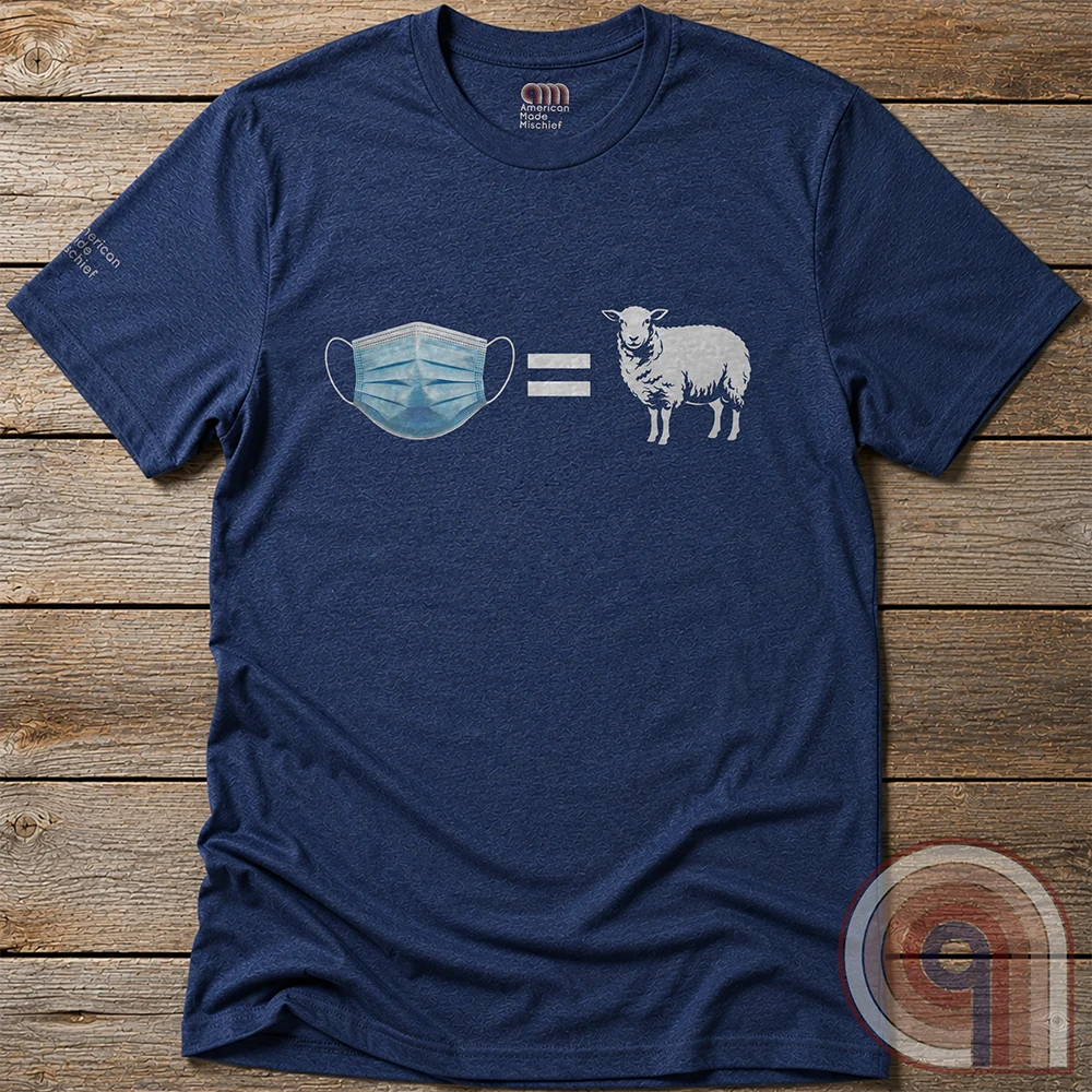 Heather navy shirt displayed flat on wooden boards, showing a medical-style blue face mask, white equals sign and sheep silhouette-like illustration.