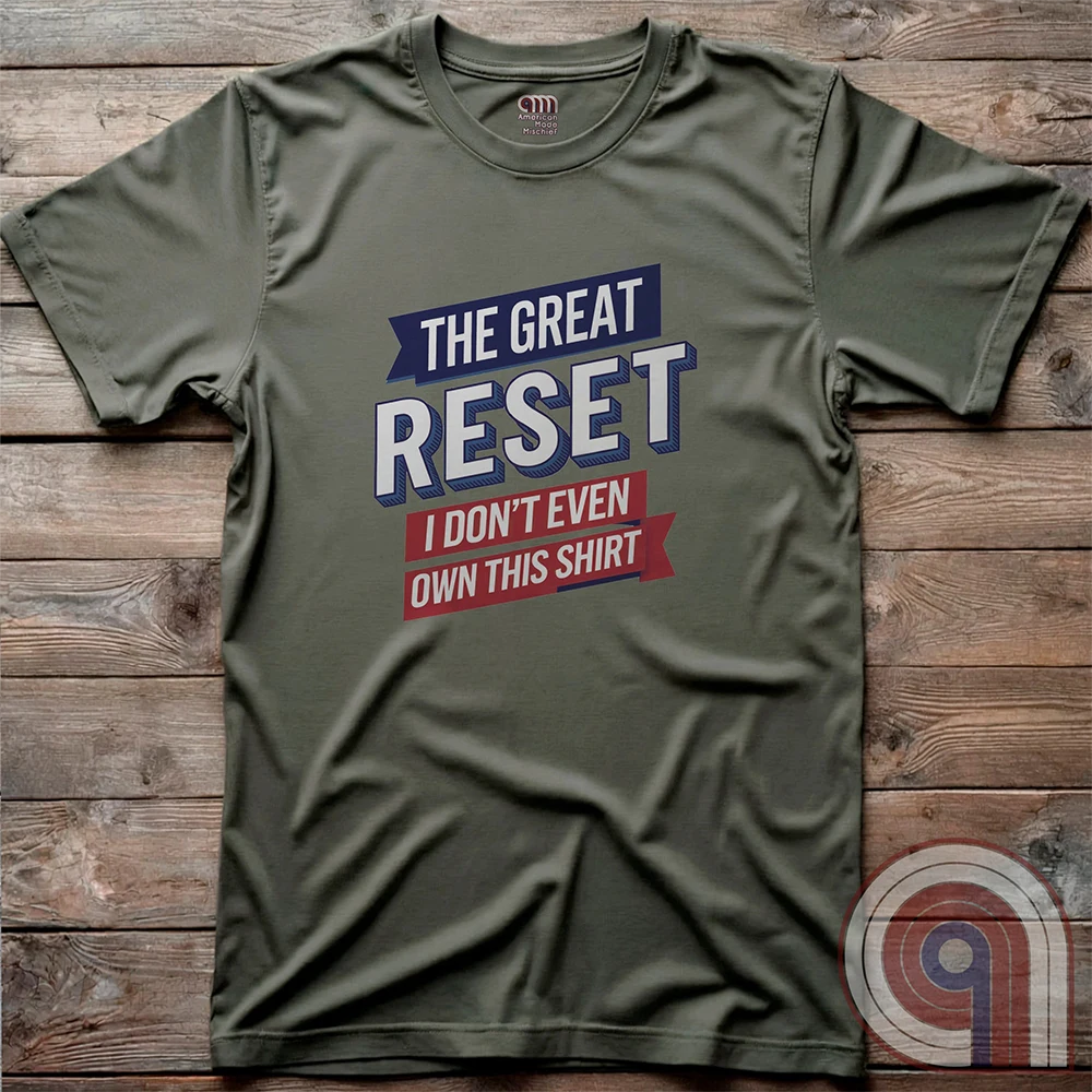 Olive green Great Reset T-shirt photographed flat on rustic wooden boards, its blue, white and red typographic design stating “THE GREAT RESET / I DON’T EVEN OWN THIS SHIRT”.